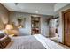 Spacious bedroom with an attached bathroom, a comfortable bed, and wood trim at 185 S Fuller Placer Rd, Breckenridge, CO 80424