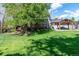 Expansive backyard with lush green lawn and mature trees, perfect for outdoor activities at 6150 Reed St, Arvada, CO 80003