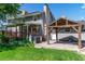 Backyard featuring a spacious deck, covered patio area, and lush green lawn for outdoor living at 6150 Reed St, Arvada, CO 80003