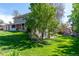 Spacious backyard featuring a lush lawn and mature trees at 6150 Reed St, Arvada, CO 80003
