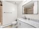 Bright bathroom with white fixtures, a marble countertop vanity, and tiled walk-in shower at 6150 Reed St, Arvada, CO 80003