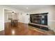 Dining area featuring a fireplace with tile surround and hearth, wood flooring, and access to another room at 6150 Reed St, Arvada, CO 80003