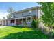 Charming two-story home features a lovely front porch, brick accents, and a well-manicured lawn at 6150 Reed St, Arvada, CO 80003
