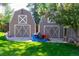 Two-car detached garage with barn-style doors and mature trees at 6150 Reed St, Arvada, CO 80003