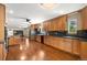 Spacious kitchen with stainless steel appliances, wood cabinets, hardwood flooring, and black countertops at 6150 Reed St, Arvada, CO 80003