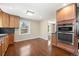 Eat in kitchen features stainless steel appliances, wood cabinets and hardwood flooring at 6150 Reed St, Arvada, CO 80003