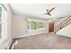 Bright living room with large window, ceiling fan, and staircase featuring hardwood railing and front door at 6150 Reed St, Arvada, CO 80003