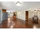 Bright living room featuring hardwood floors, updated lighting, and an open floor plan to the kitchen at 6150 Reed St, Arvada, CO 80003