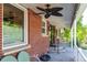 Relaxing covered brick porch with ceiling fan, perfect for enjoying the outdoors with style at 6150 Reed St, Arvada, CO 80003