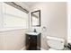 Bright half bath with a vanity with modern sink and fixtures at 6150 Reed St, Arvada, CO 80003