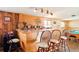 Basement bar area featuring wood paneling, stools, and an open layout at 470 Mcdonnell St, Byers, CO 80103