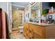 Bathroom featuring stone-tiled shower, granite countertops, wooden cabinets, and updated fixtures at 470 Mcdonnell St, Byers, CO 80103