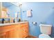 Bathroom with double vanity, wooden cabinets, granite countertops, and blue walls at 470 Mcdonnell St, Byers, CO 80103