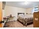 Bedroom featuring wood-look floors, a plaid bedspread, and a small desk at 470 Mcdonnell St, Byers, CO 80103