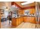Kitchen with breakfast bar, light wood cabinets, and view into the dining area at 470 Mcdonnell St, Byers, CO 80103