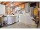 Unfinished laundry area with washer, dryer, utility sink, shelving, and an efficient hot water heater at 470 Mcdonnell St, Byers, CO 80103