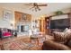 Cozy living room with brick fireplace, ceiling fan, wood floors and stylish furnishings at 470 Mcdonnell St, Byers, CO 80103