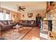 Comfortable living room with brick fireplace, wood floors, ceiling fan, and ample seating at 470 Mcdonnell St, Byers, CO 80103