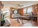 Living room featuring wood paneling, cozy couches, neutral decor, and natural light at 470 Mcdonnell St, Byers, CO 80103