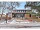 Two-story home with gray siding and brick accents, in a snowy neighborhood at 7910 E Bethany Pl, Denver, CO 80231