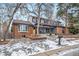 Brick two-story home with gray accents, snowy front yard, and a covered porch at 7910 E Bethany Pl, Denver, CO 80231