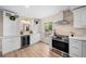 Bright kitchen with white cabinets, stainless steel appliances, and wine cooler at 7910 E Bethany Pl, Denver, CO 80231