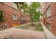 Backyard area with brick building, some greenery, and a tile patio at 1060 N Washington St # 1A, Denver, CO 80203
