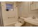 Clean bathroom featuring white tiled walls, a bathtub, and a toilet at 1060 N Washington St # 1A, Denver, CO 80203