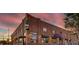 Exterior of a brick restaurant with a large champagne bottle sign against a colorful sunset at 1060 N Washington St # 1A, Denver, CO 80203