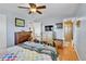 Bedroom featuring hardwood floors, a metal bedframe, and an ensuite bathroom at 3266 S Wabash Ct, Denver, CO 80231