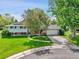 Traditional two-story home with a well-manicured front lawn, mature trees, and attached two-car garage at 3266 S Wabash Ct, Denver, CO 80231
