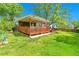 Charming single-story home featuring a covered wooden porch, well-maintained lawn, and mature trees at 3266 S Wabash Ct, Denver, CO 80231