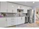 Modern kitchen featuring white cabinets, stainless steel appliances, and a gray backsplash at 3266 S Wabash Ct, Denver, CO 80231