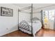Bedroom with hardwood floors, a four-poster bed, and a window providing natural light at 6327 S Emporia Cir, Englewood, CO 80111