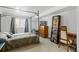 Cozy bedroom featuring plush carpet, a four-poster bed, and a window at 6327 S Emporia Cir, Englewood, CO 80111