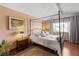 Charming bedroom with a four-poster bed, hardwood floors, and natural light from the large window at 6327 S Emporia Cir, Englewood, CO 80111