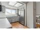 Kitchen with gray cabinets, stainless steel refrigerator, and wood floors at 6327 S Emporia Cir, Englewood, CO 80111