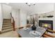 Inviting dining area with a cozy fireplace and staircase access, creating a warm and welcoming atmosphere at 3974 W 118Th Pl, Westminster, CO 80031