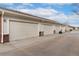 Row of garages showing neutral doors and red brick accents with driveway in front at 3974 W 118Th Pl, Westminster, CO 80031