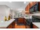 Modern kitchen with wood cabinets, granite countertops, stainless appliances, and a view of the living area at 3974 W 118Th Pl, Westminster, CO 80031