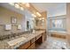 Bright bathroom with double sinks, granite countertops, and a soaking tub at 10900 Parker Vista Rd, Parker, CO 80138