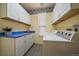 Bright laundry room with white cabinets, blue countertops, and modern appliances at 10900 Parker Vista Rd, Parker, CO 80138