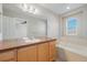 Bathroom with wooden cabinets and bathtub at 8735 E 29Th Pl, Denver, CO 80238