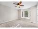 Bedroom with carpet flooring, ceiling fan, and large window at 8735 E 29Th Pl, Denver, CO 80238