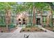 Brick townhouse exterior with front yard landscaping and trees providing shade at 8735 E 29Th Pl, Denver, CO 80238