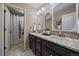 Bathroom featuring double vanity with granite countertop, decorative mirrors, and a shower with curtain at 2028 Treetop Dr, Castle Rock, CO 80109