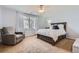 Serene bedroom with neutral tones, a large bed, and a cozy armchair at 6853 W Rockland Pl, Littleton, CO 80128