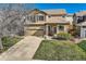 Inviting two-story home with a manicured lawn, an attached two-car garage, and a cozy front porch at 6853 W Rockland Pl, Littleton, CO 80128