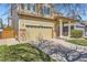Two-story home with a two-car garage, covered porch with pillars, and manicured lawn at 6853 W Rockland Pl, Littleton, CO 80128