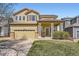 Charming two-story home features a welcoming covered porch, a two-car garage, and a well-manicured lawn at 6853 W Rockland Pl, Littleton, CO 80128